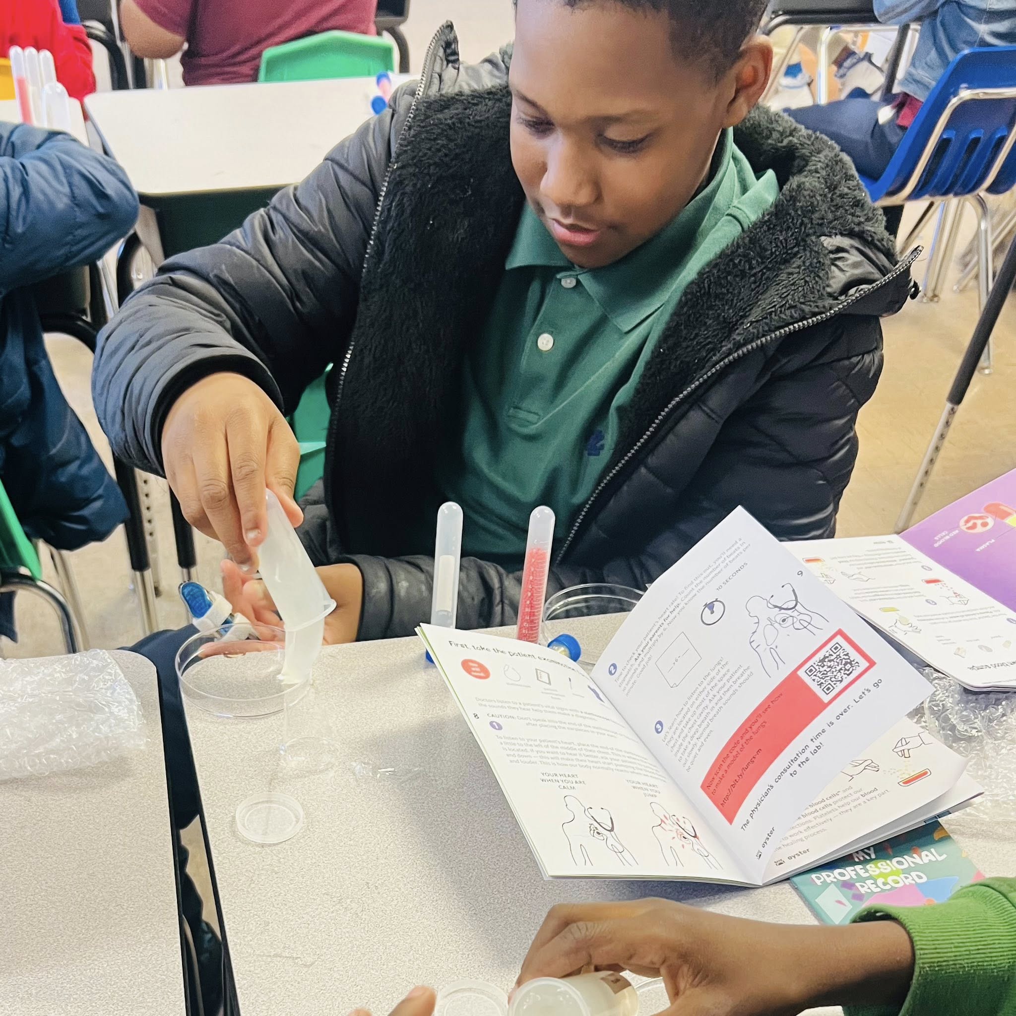 A boy pouring an opaque substance into a petri dish.
